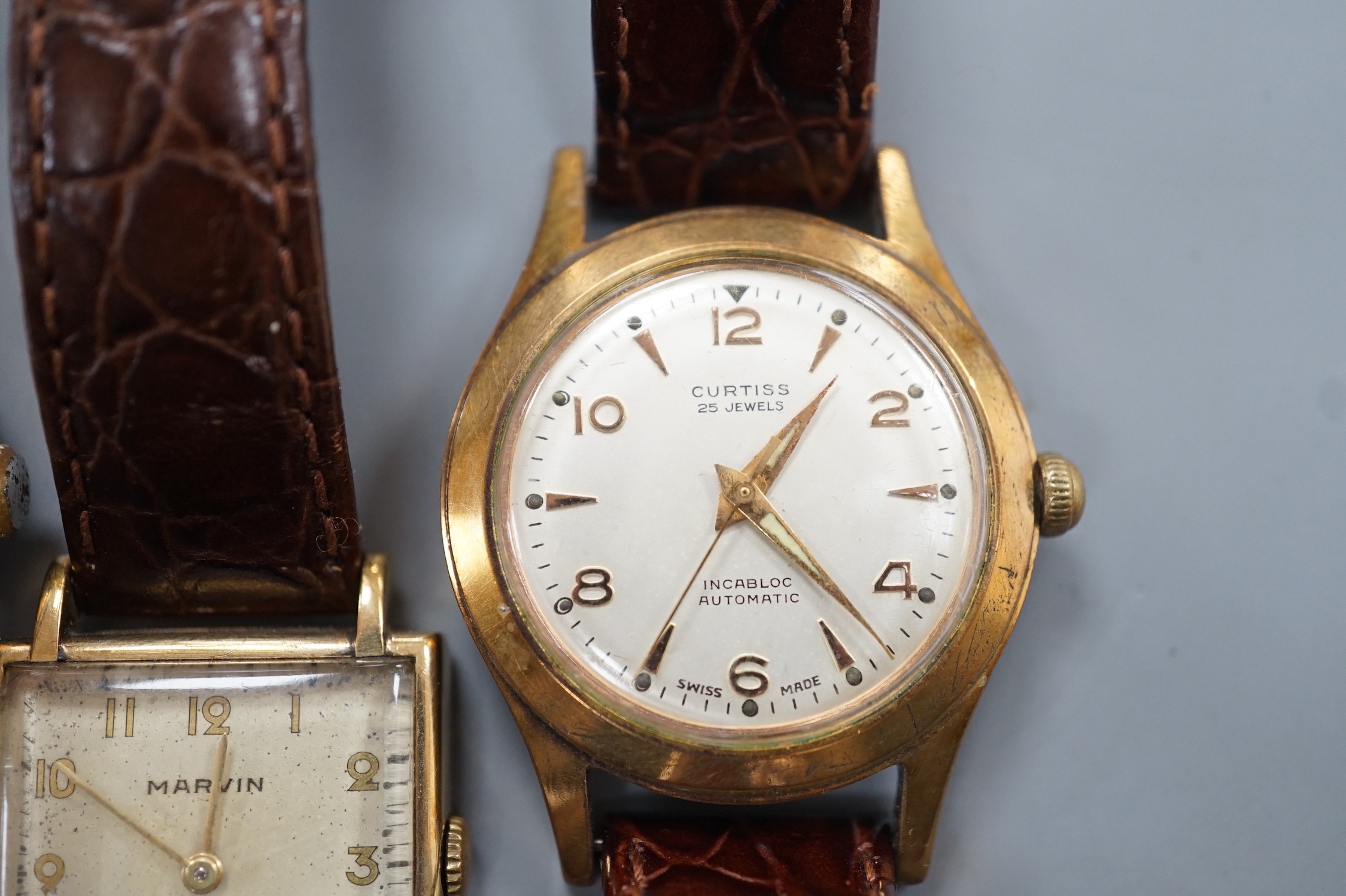 A gentleman's 1940's 9ct gold Marvin square dial manual wind wrist watch, on a later leather strap, together with two other gentleman's steel and gold plated wrist watches, Cornavin and Curtiss automatic.